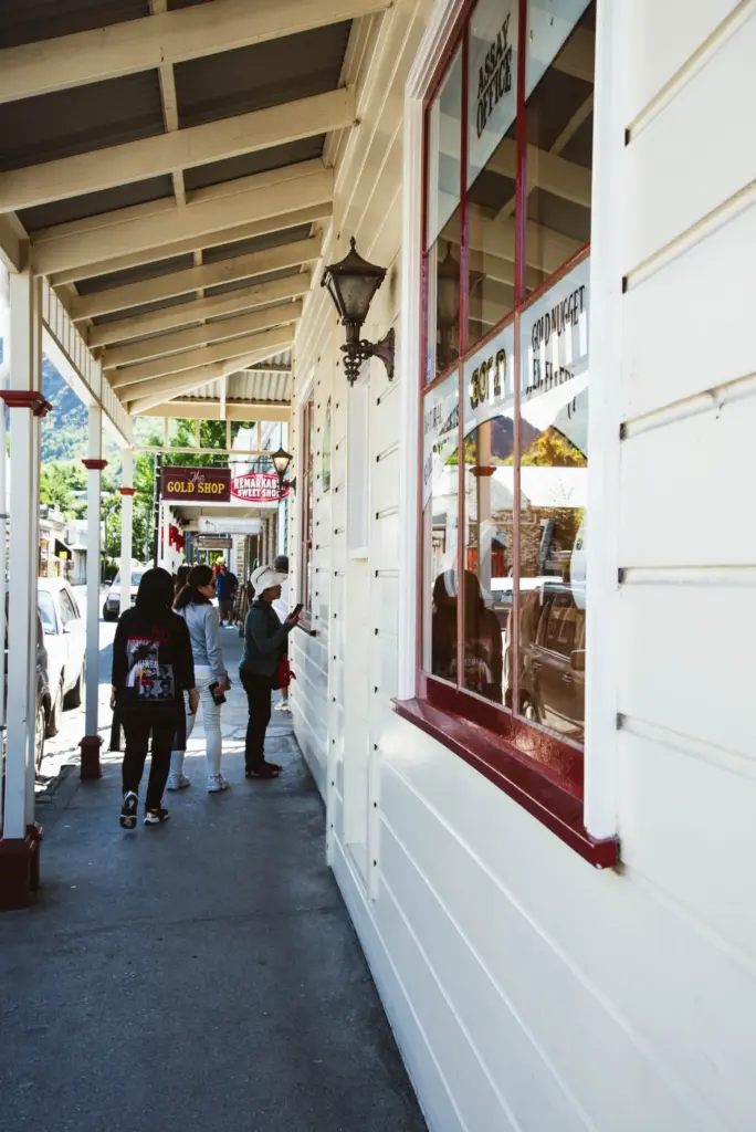 People walking along a covered footpath in the historic main street of Arrowtown.