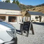 Exterior of a winery and tasting area in Gibbston Valley with a tour van nearby.