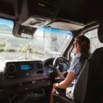 Tour guide driving a Mercedes van through Queenstown during a sightseeing tour.