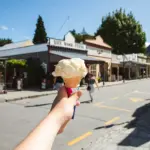 Hand holding an ice cream cone on the main street in Arrowtown.