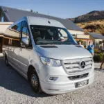 Silver Mercedes tour van parked outside a winery in Gibbston Valley.
