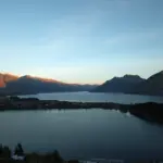 Sunset view over Lake Wakatipu and Queenstown with mountains in the background.