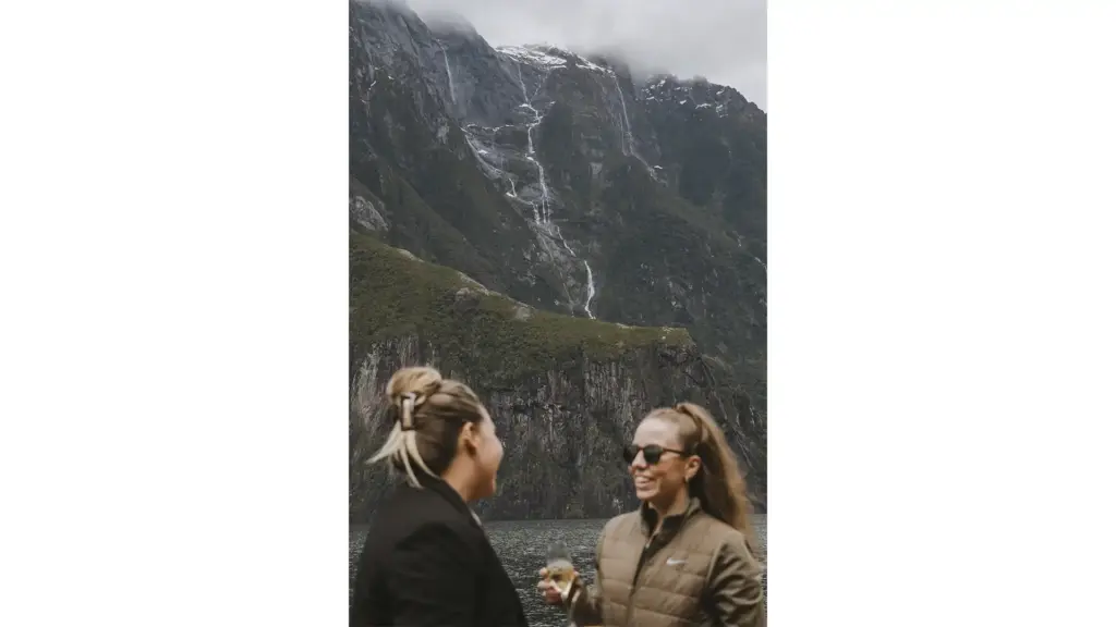 Guests on a Milford Sound cruise viewing waterfalls and steep fiord cliffs