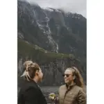 Guests on a Milford Sound cruise viewing waterfalls and steep fiord cliffs